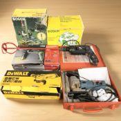 A group of power tools including DeWalt angle grinder, Black & Decker drill, other items by Bosch,