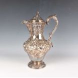 An early Victorian Scottish silver hot water pot of baluster form with hinged lid and foliate finial