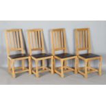 A set of four Robert 'Mouseman' Thompson oak framed rail back dining chairs, the seats upholstered