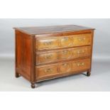 An 18th century French oak three-drawer commode, the front with carved reserves and with applied