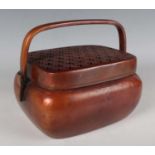 A Chinese copper alloy handwarmer, Qing dynasty, of rounded rectangular form with overhead swing