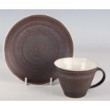A Lucie Rie and Hans Coper studio pottery stoneware cup and saucer, circa 1958, the cup exterior and