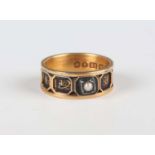 An early Victorian 18ct gold, black enamelled and half-pearl set mourning ring, detailed ‘In