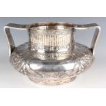 A late Victorian silver trophy cup of squat baluster form, the fluted cylindrical neck decorated