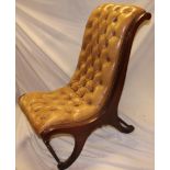 A reproduction mahogany easy chair upholstered in brown buttoned leather