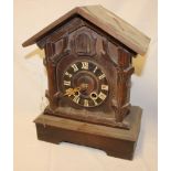 An old Black Forest stained wood cuckoo clock with rectangular base,