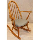 A 1970's/80's Ercol pale elm rocking chair with hoop back on turned supports