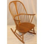 A 1960s Ercol pale elm traditional rocking chair with spindle-back and shaped seat on tapered legs