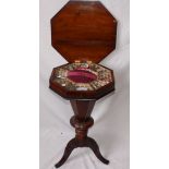 A Victorian inlaid walnut octagonal work table with fitted interior enclosed by a hinged cover on