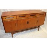 A 1960's G-Plan teak sideboard with three drawers in the frieze and cupboards enclosed by four