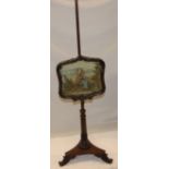 A Victorian rosewood pole screen with needlework tapestry panel depicting a boy seated within a