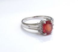 A 9ct white gold fire opal and diamond ring, the central fire opal flanked by three diamonds. Size