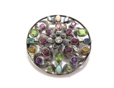 A circular multi-stone set brooch, including amethysts, peridot, garnet, ruby, sapphire and opal