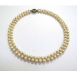 A double strand pearl necklace with a 9ct gold garnet and pearl star shaped clasp, 41cm long