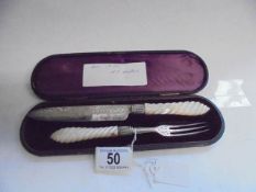 A cased serving knife and fork with silver blades and mother of pearl handles, Birmingham 1872,