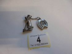 A horse related silver pendant being a riding boot and a horse shoe.