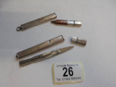 A pair of folding scissors in a silver case and a silver cased pencil.