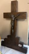 An antique wooden crucifix with metal figure of Jesus inscribed at bottom of cross