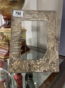 A metal picture frame with highly detailed East Asian architectural design