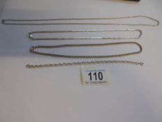 Three silver neck chains and a silver bracelet.