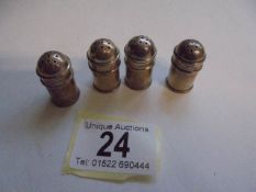 Four small silver pepper pots.