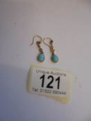 A pair of turquoise and seed pearl earrings.