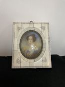 An oval portrait of a lady in an ivorex frame.