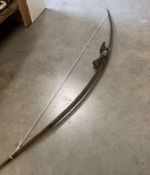 A vintage tribal recurve bow and arrow.