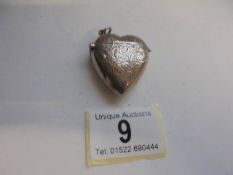 A silver heart shaped pendant pill box.