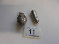 A monogrammed silver pendant pill box and a silver pendant scent bottle.