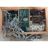 A wooden jewellery box containing assorted costume jewellery.