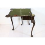 George II mahogany fold-over games table, the top exposing four inset circular candle stands and