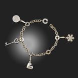 BULGARI A GOLD CHARM BRACELET, suspending three Bulgari charms and key-shaped charm by Tiffany & Co,