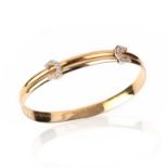 CARTIER, A FLEXIBLE GOLD AND DIAMOND 'C DE CARTIER' BANGLE, with two diamond-set Cs on expanding
