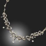 A DIAMOND NECKLACE, designed as a row of diamond-set vine leaves centring on a row of graduating