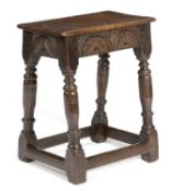 A CHARLES I OAK JOINT STOOL GLOUCESTERSHIRE, C.1640 the seat with a moulded edge above a foliate
