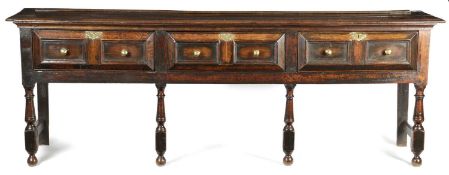 A CHARLES II OAK DRESSER C.1680 the boarded top above three mitre moulded drawers, on baluster and