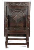 AN OAK TABLE-CHAIR 17TH CENTURY AND LATER the hinged sliding top with lunette carved band and