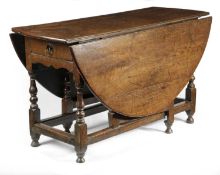 A QUEEN ANNE OAK GATELEG TABLE EARLY 18TH CENTURY the oval drop-leaf top on baluster turned legs