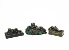 THREE BRONZE SLEEPING CHERUB PAPERWEIGHTS 19TH CENTURY one on a lit en bateau, another on a black