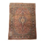 A KASHAN RUG CENTRAL PERSIA, C.1930 the terracotta field profusely decorated with vines, around an