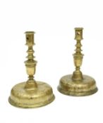 A NEAR PAIR OF SPANISH BRASS CANDLESTICKS C.1680 each with a domed circular base above a ring turned