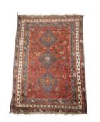 A KHAMSEH CARPET C.1930 the madder field of tribal and zoomorphic devices around three mid blue