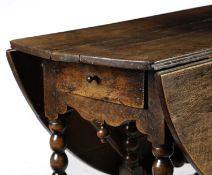 A WILLIAM AND MARY OAK GATELEG TABLE C.1690 the oval drop-leaf top on bobbin turned supports 74.
