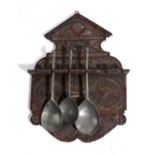 A TREEN OAK SPOON RACK 19TH CENTURY with chipped carved whorl and lunette decoration, with six