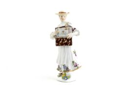 A MEISSEN TYROLEAN FEMALE STREET VENDOR C.1740 she stands with an open trinket box, the base applied
