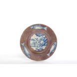 A DELFTWARE PLATE PROBABLY LONDON, C.1750 blue painted with a Chinese figure beside a lake, on a