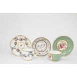 A SEVRES CUP AND SAUCER C.1795 painted with a pink rose spray inside a green and gilt 'fond