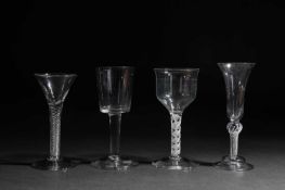 FOUR LARGE WINE GLASSES MID-18TH CENTURY AND LATER comprising: one with a bucket bowl on a plain