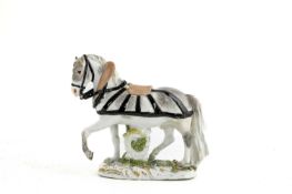 A SMALL MEISSEN MODEL OF A HORSE C.1750 in full harness with the front left leg raised 12.5cm